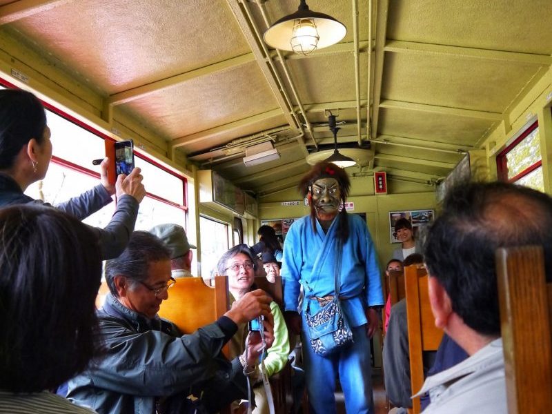 Japanese guy with fierce looking mask in Sagano Scenic Train